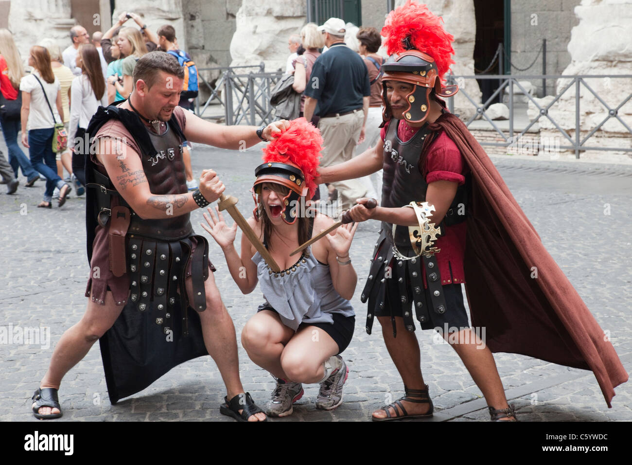 Italia, Roma, turista femminile in posa con gli uomini in costumi Gladiator Foto Stock