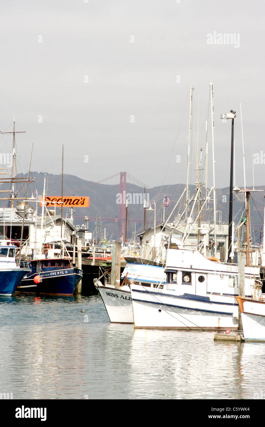 Barche ormeggiate presso il Fisherman's Wharf di San Francisco con il Golden Gate Bridge in background Foto Stock