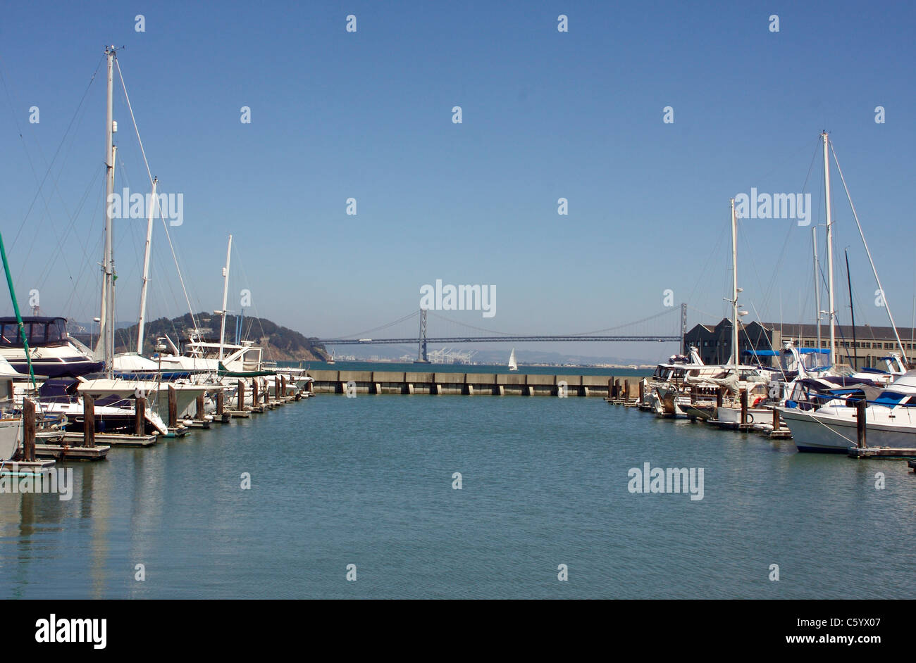 Barche ormeggiate in San Francisco Harbour con una vista del Ponte della Baia Foto Stock