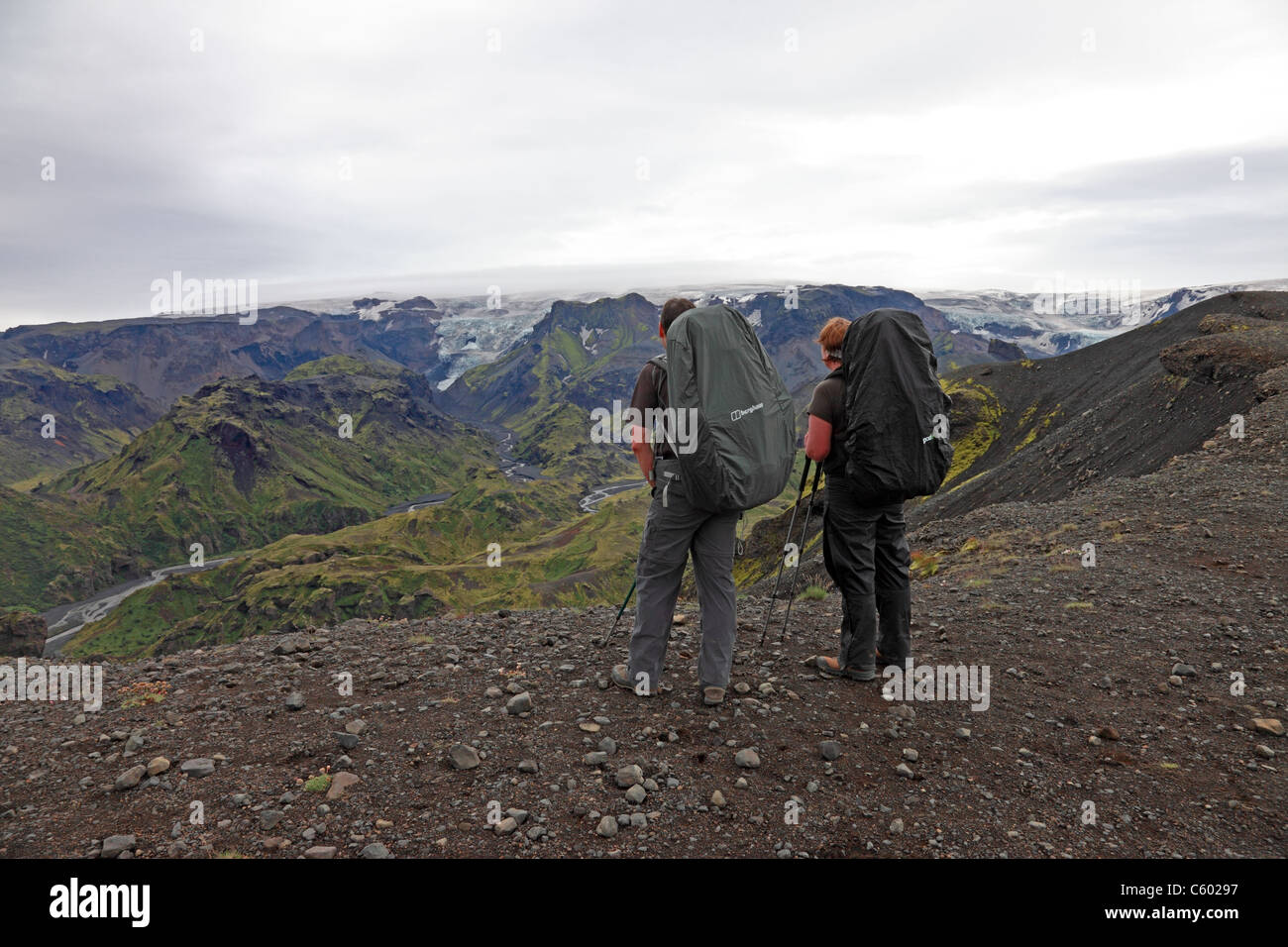 2 escursionisti e vista dalla cresta Kattarhryggir, Gooaland guardando verso il vulcano Katla coperto dal ghiacciaio Myrdalsjokull, Islanda Foto Stock