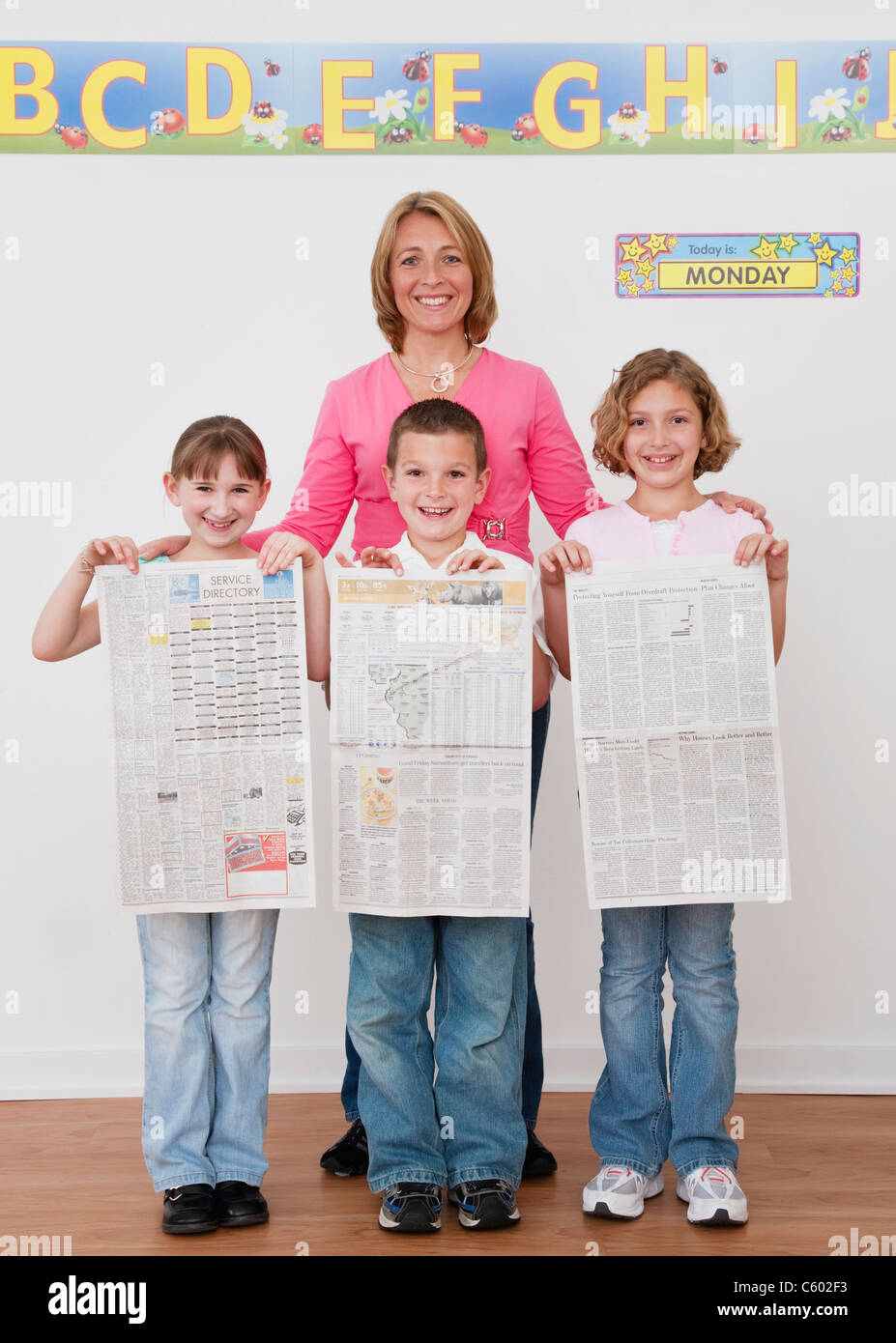 Stati Uniti d'America, Illinois, Metamora, insegnante in piedi con i bambini (6-7, 8-9) azienda quotidiani Foto Stock