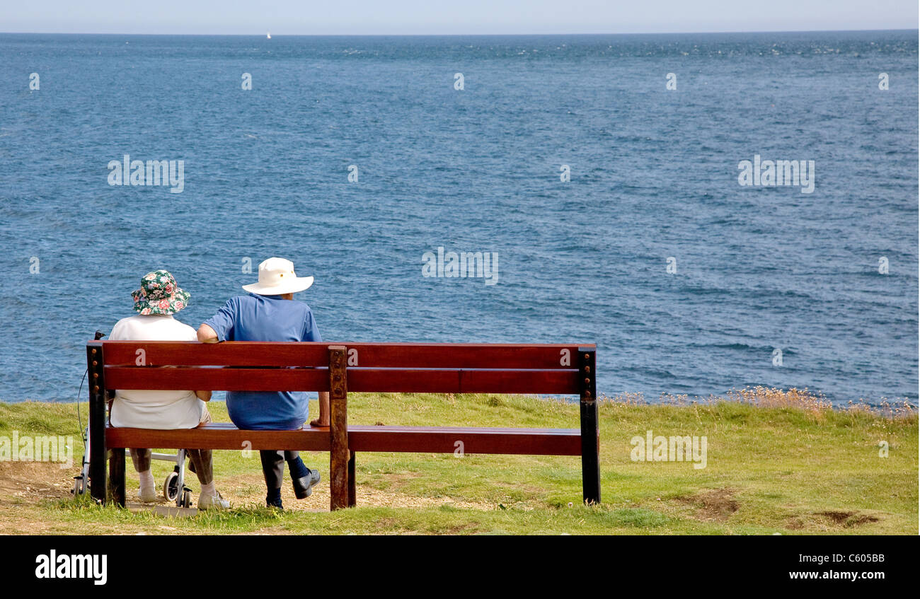 Un vecchio paio di sedersi su una scogliera sede sulla costa sud dell'Inghilterra che si affaccia sul canale in lingua inglese Foto Stock