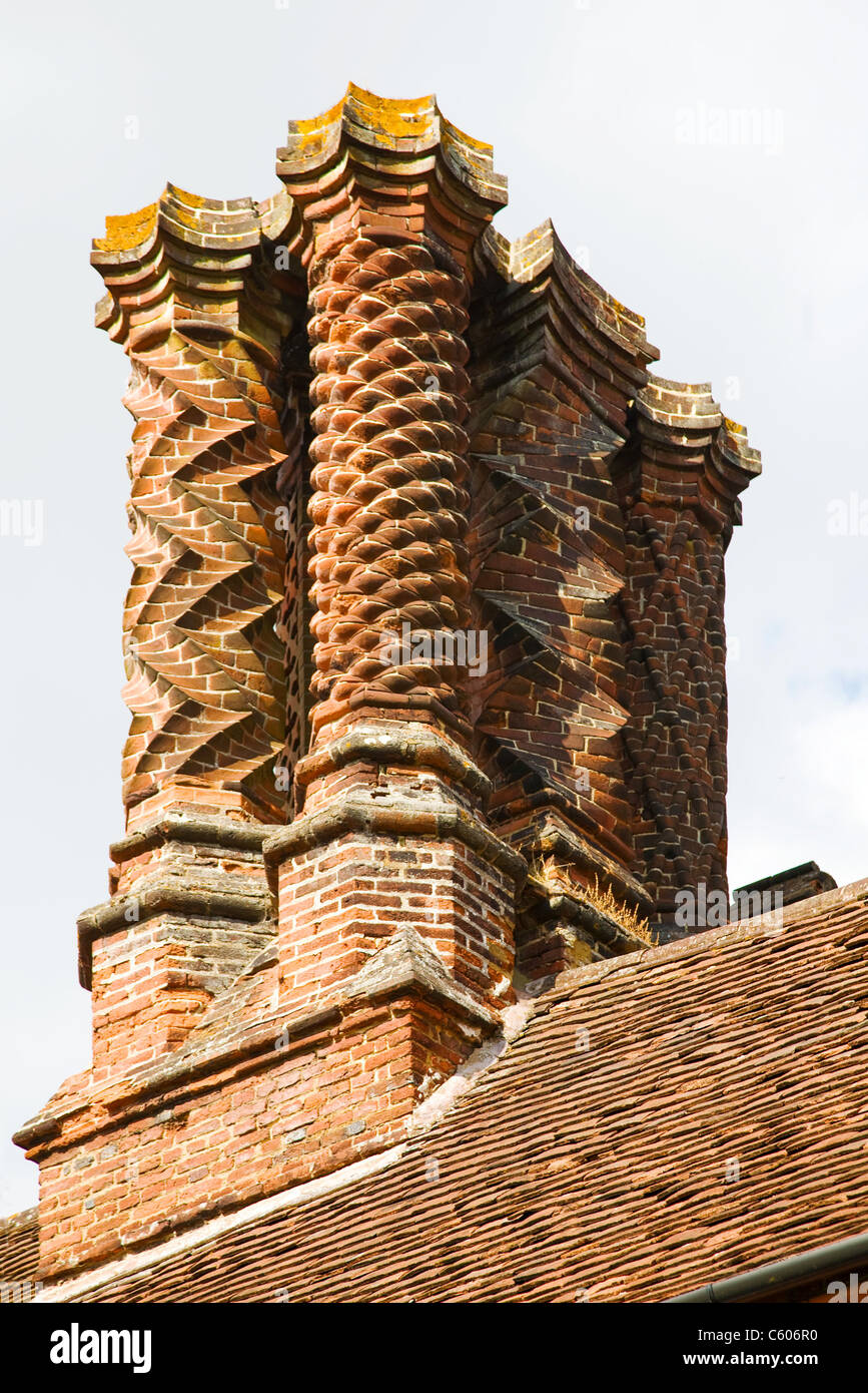 Comignoli decorativi costruito da scolpita in mattoni in stile giacobino su un edificio in inglese Foto Stock