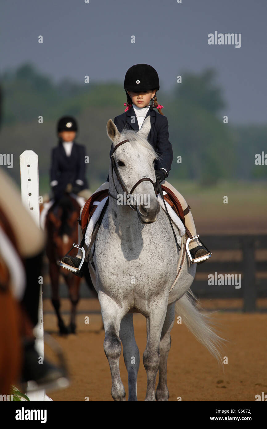 Un giovane pilota e il suo cavallo competere sul piatto in uno spettacolo di cavalli. Foto Stock