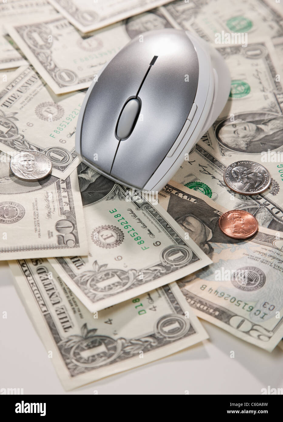 Stati Uniti d'America, Illinois, Metamora, mouse del computer e noi monete giacente sulla carta moneta Foto Stock