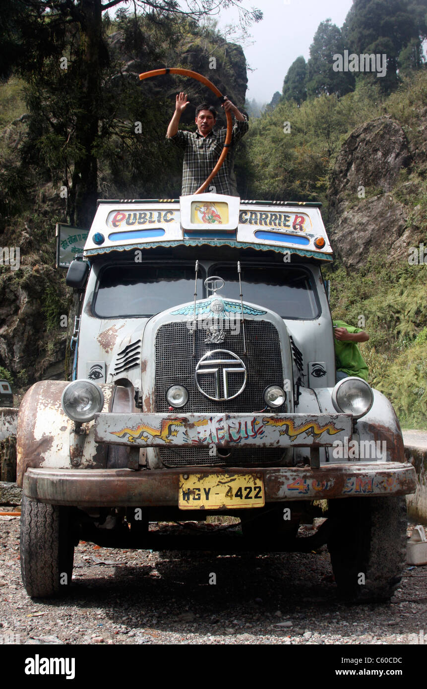 Vintage Tata 1210 SE acqua bowser alimentando acqua locale il riempimento delle cisterne su strada di campagna vicino a Darjeeling, India Foto Stock