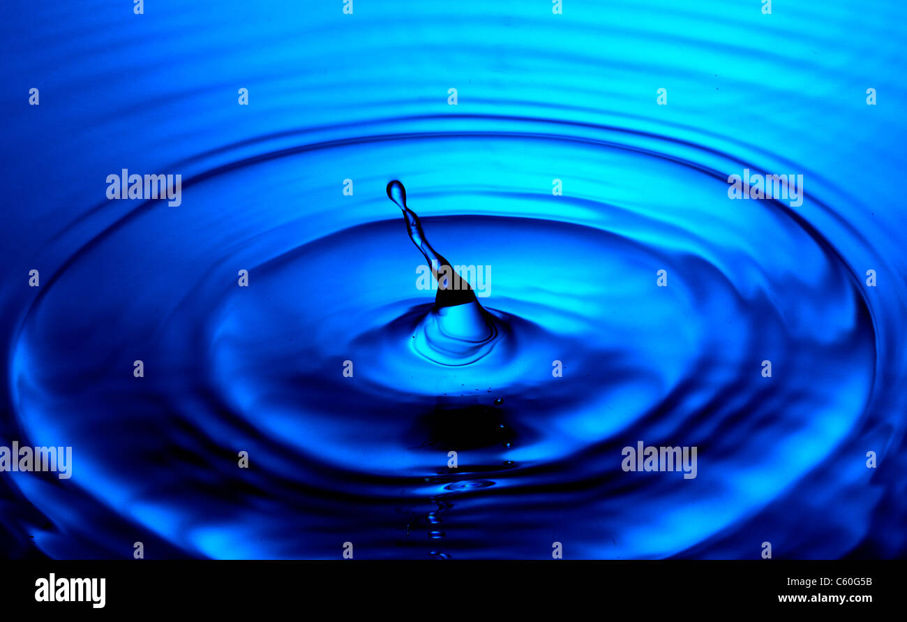 Una gocciolina d'acqua, con ondulazioni di blu Foto Stock