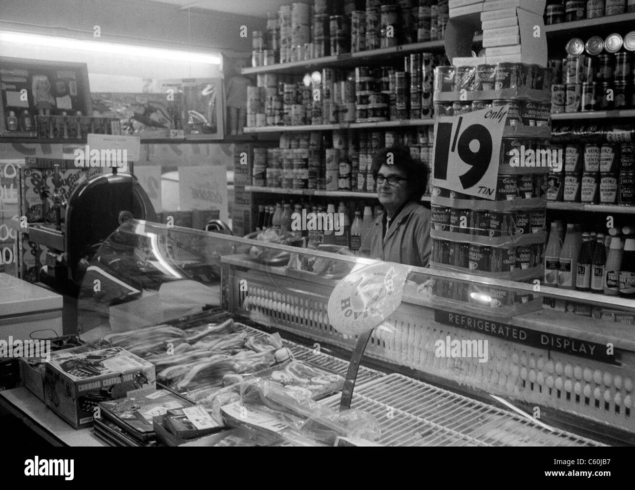 Negoziante nel suo negozio di alimentari Harold Park, Essex, Inghilterra, ottobre 1969 mostra prezzo di 1/9 pre sterlina decimale Foto Stock
