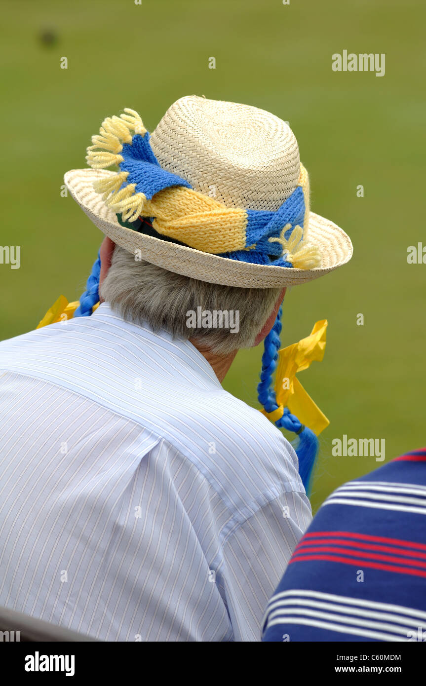 L'uomo con i colori della contea sul cappello di paglia guardando donne partita di bocce Foto Stock