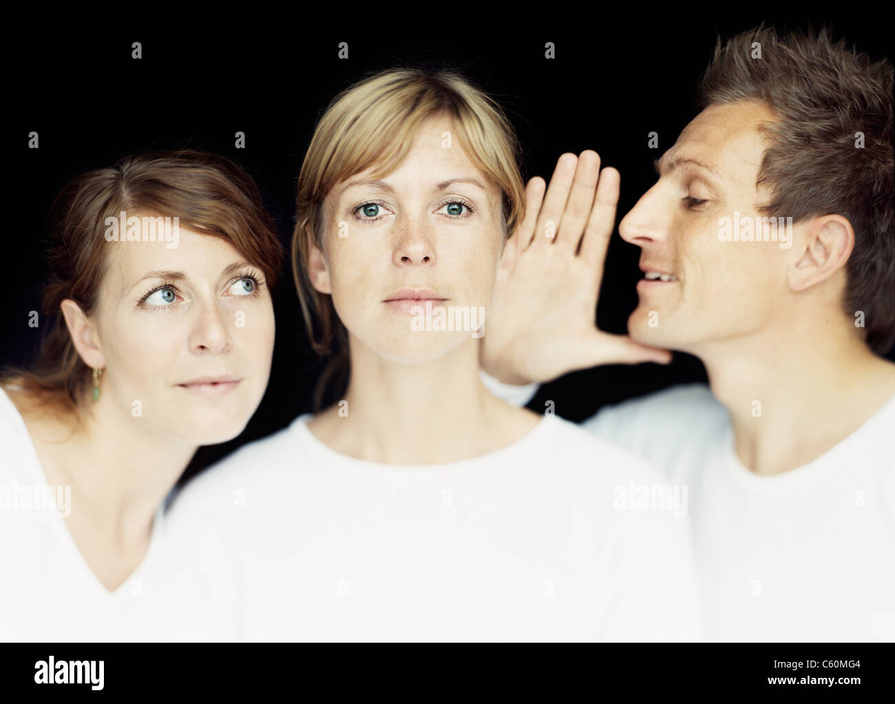 L'uomo whispering nella donna di orecchio Foto Stock