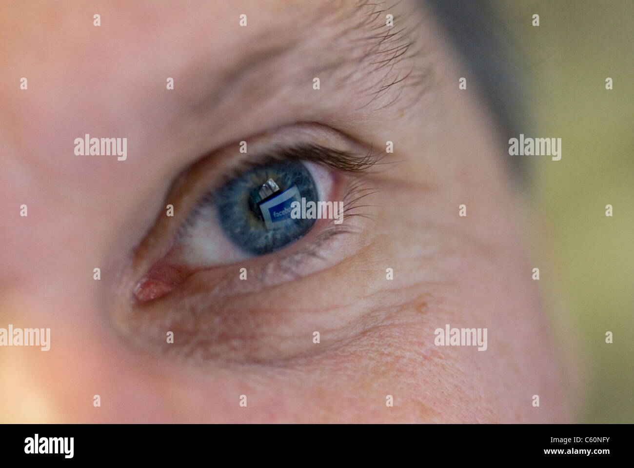 Close-up di un uomo blu dell'occhio sinistro con facebook riflessa in esso Foto Stock