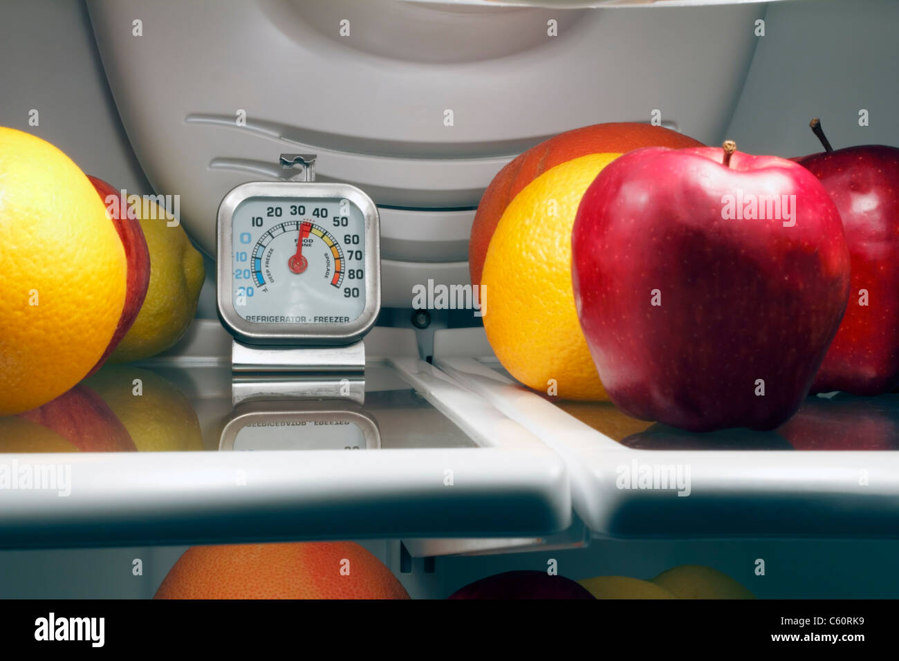 Termometro per frigorifero all'interno della mensola superiore di un fresco nella conservazione di alimenti frigo per vedere i beni deperibili sono mantenuti sicuri e freddo. Termometro per frigorifero per la sicurezza. Foto Stock