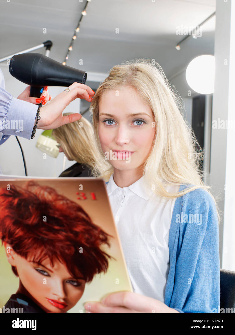 Donna con capelli essiccato in salone Foto Stock