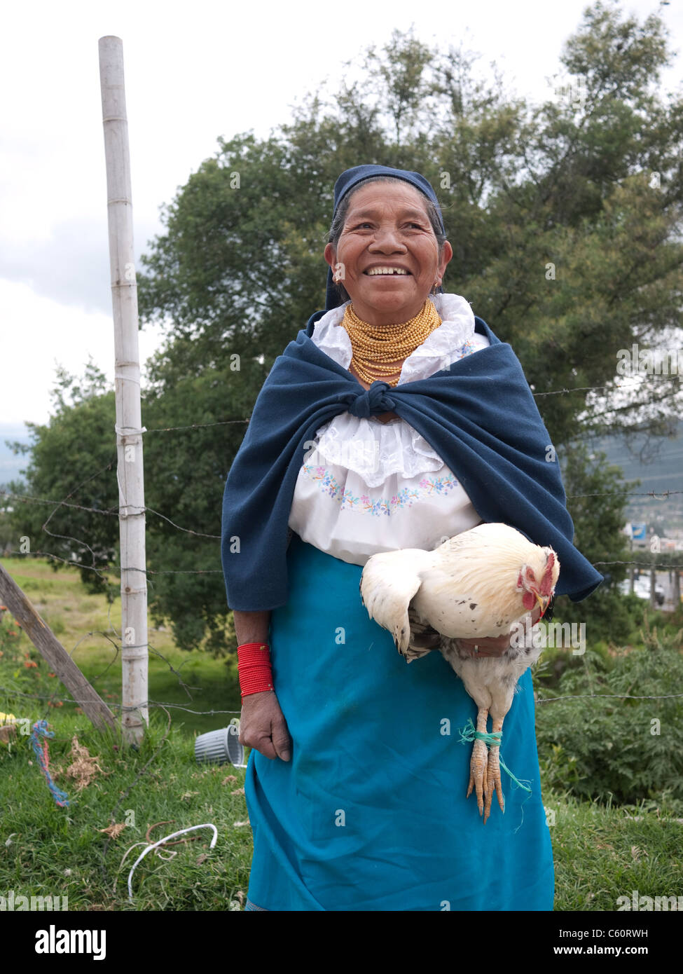 Sud Americana donna in abito tradizionale mentre tiene il suo rooster. Foto Stock