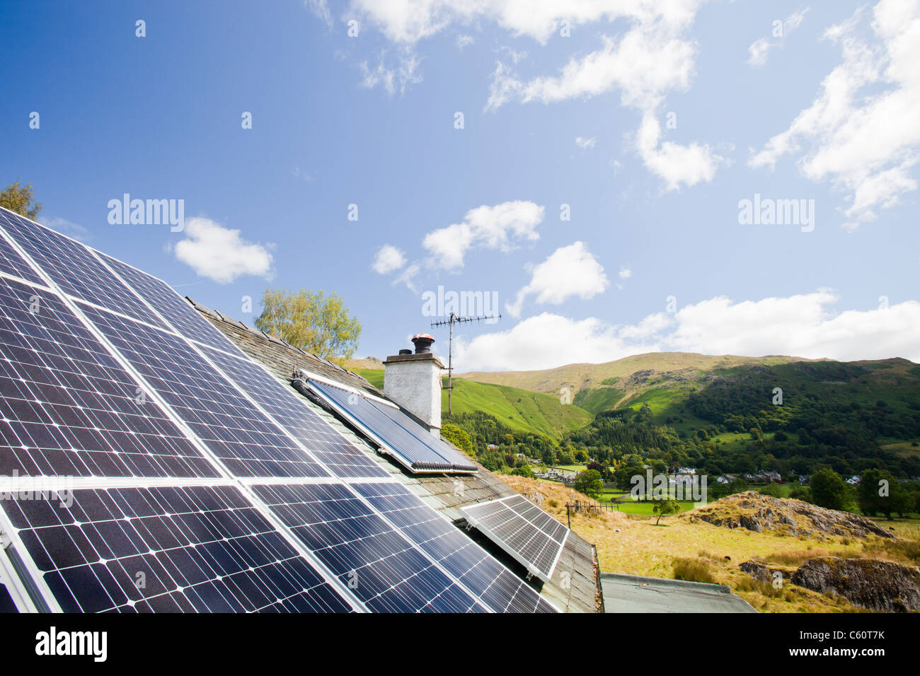Solar Electric (foto voltaico) e solare termico (acqua calda) pannelli su un tetto di casa a Grasmere, Lake District, UK. Foto Stock