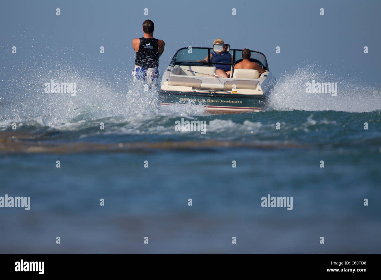 Uno slalom waterskier alzarmi dietro una barca. Foto Stock