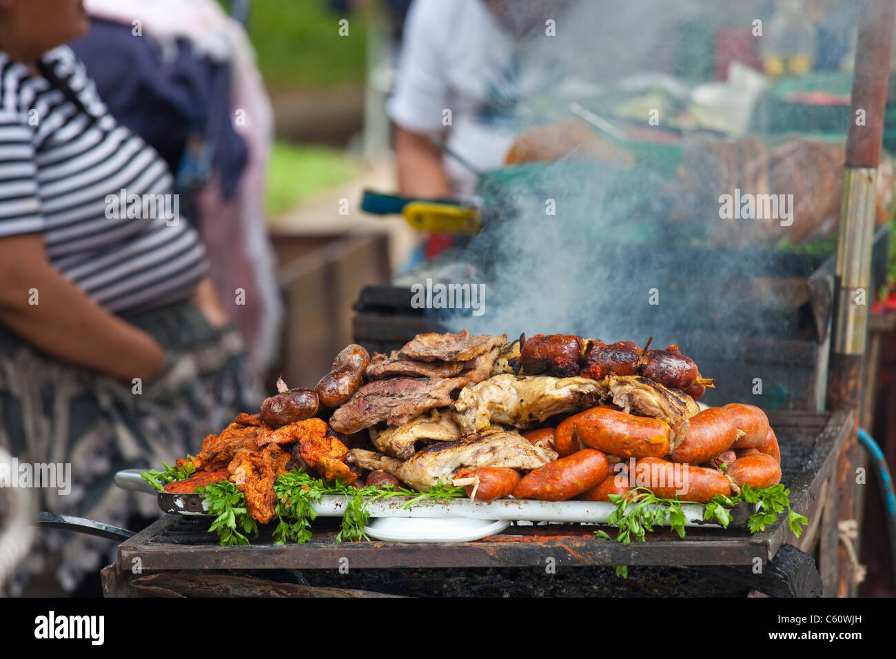 Cucina di strada venditore cuocere carne, Antigua, Guatemala Foto Stock