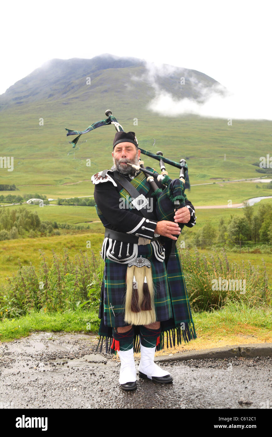 Bagpiper nelle Highlands della Scozia Foto Stock