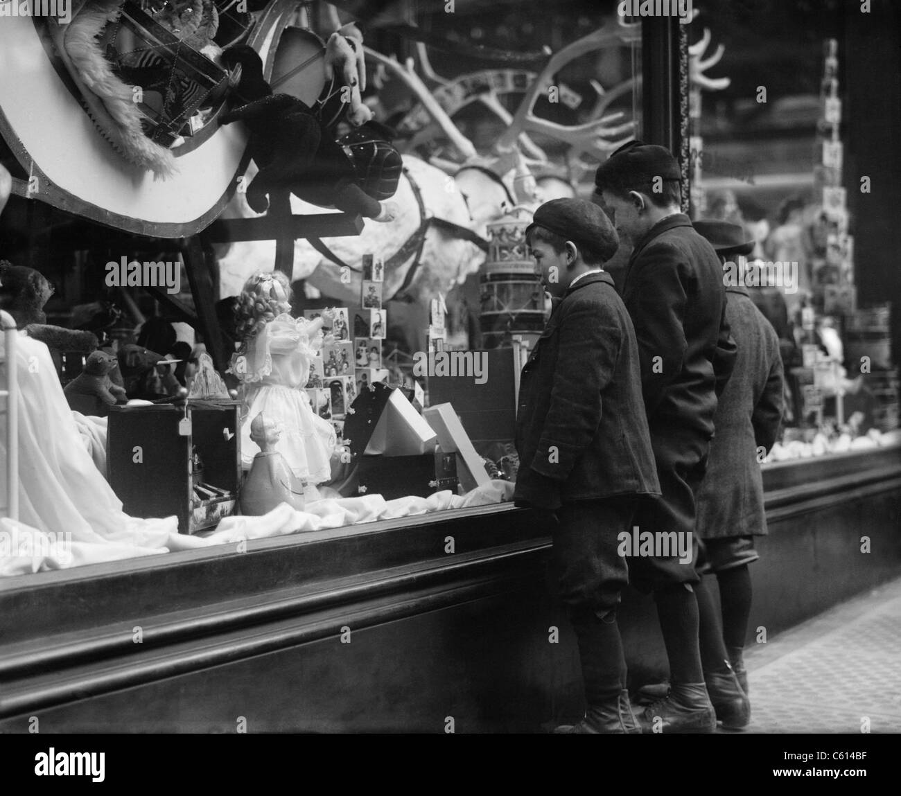 Tre ragazzi mesmerized dai giocattoli di Natale in vetrina nella città di New York. Ca. 1915. (BSLOC 2010 18 108) Foto Stock