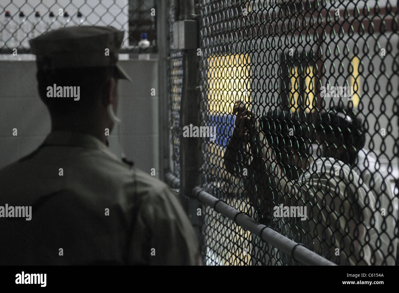 Stati Uniti Sailor sorge vegli su di un blocco di cella a U.S. Stazione navale di Guantánamo Bay carcere militare mentre i detenuti guardare attraverso riviste e libri 30 marzo 2010., foto di:Everett raccolta(BSLOC 2011 6 150) Foto Stock