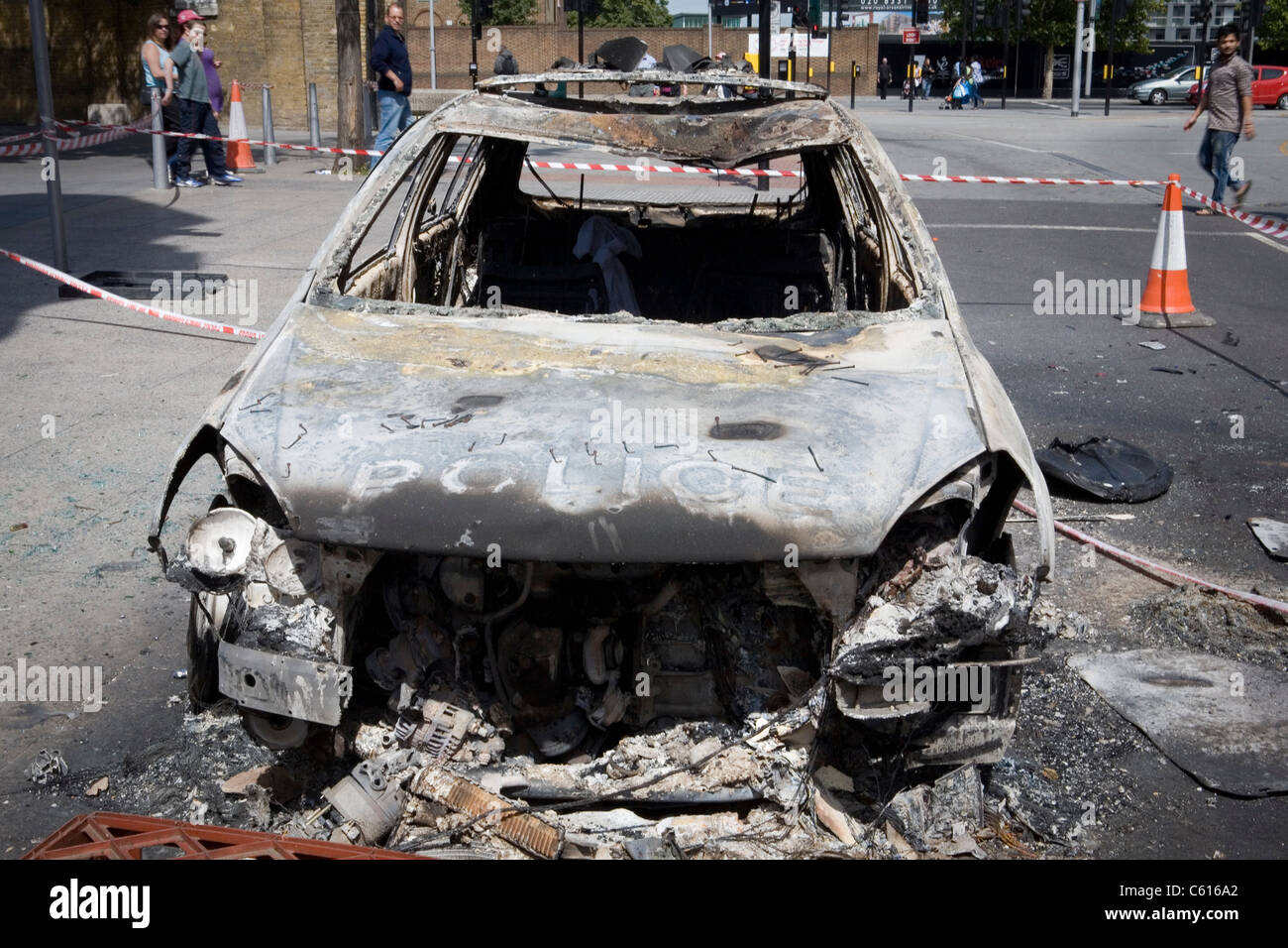 Una vettura si siede completamente bruciato nel centro di Woolwich, a sud-est di Londra, dopo una notte di disordini e saccheggi. Foto Stock