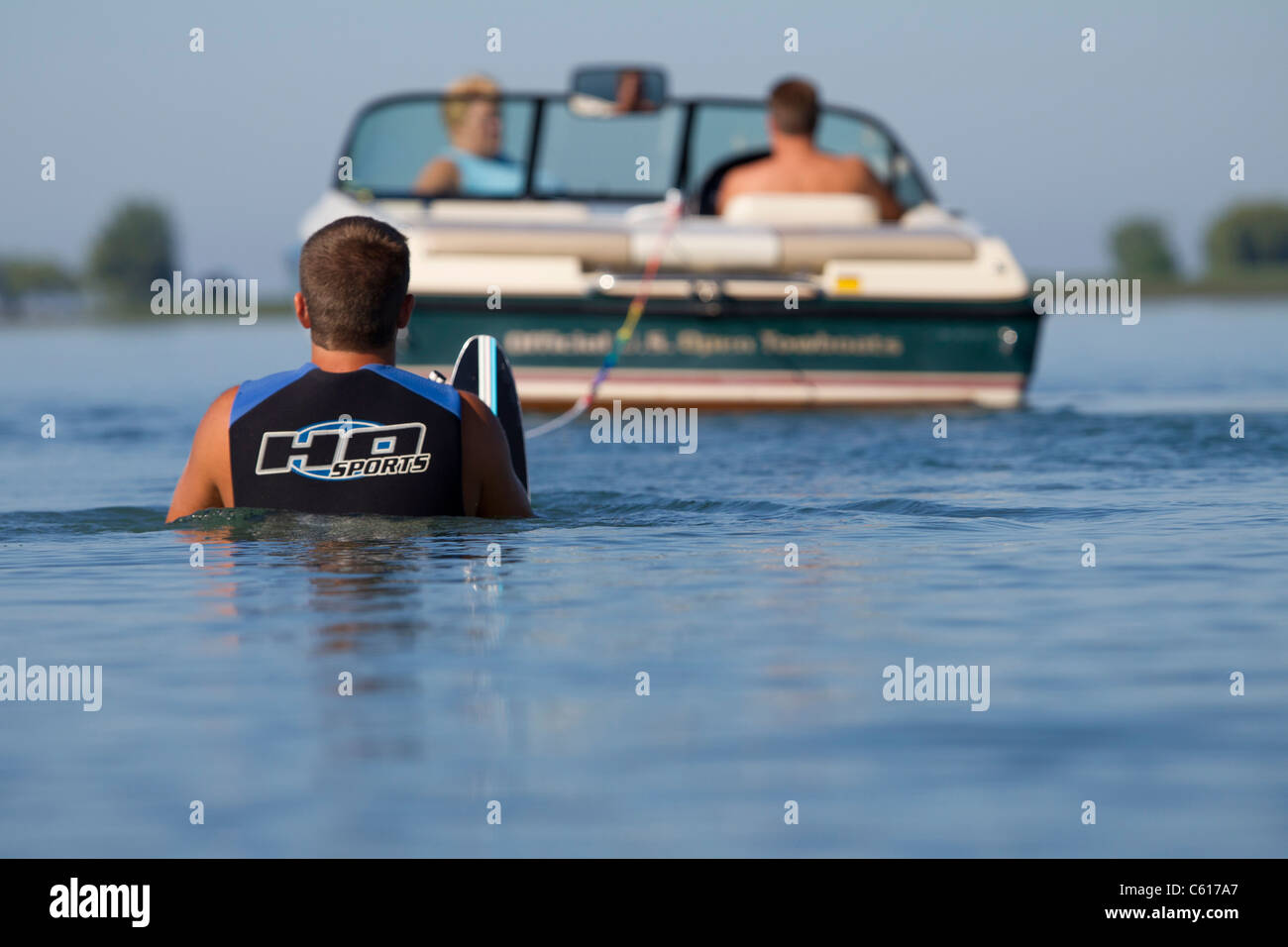 Uno sciatore in piedi in acqua dietro la barca di traino pronto per iniziare. Foto Stock