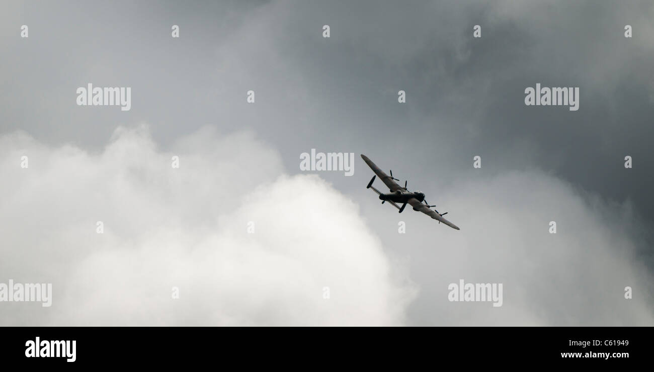 Una seconda guerra mondiale Avro Lancaster bombardiere, parte della Battaglia di Bretagna volo, REGNO UNITO - in volo, grigio nuvole nere Foto Stock