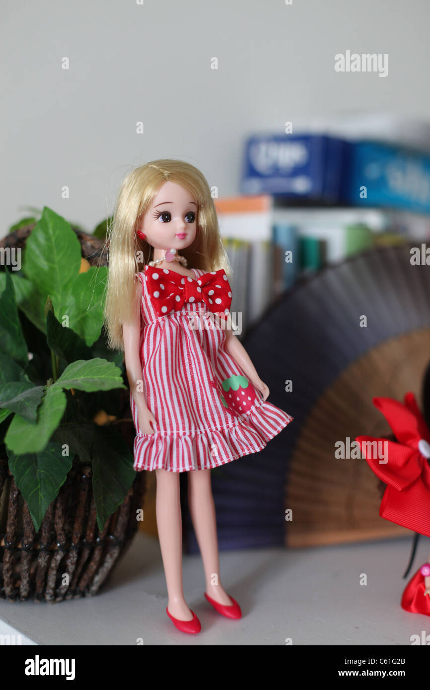 La bionda bambola Barbie in abito rosa con un rosso Tie collo Foto Stock