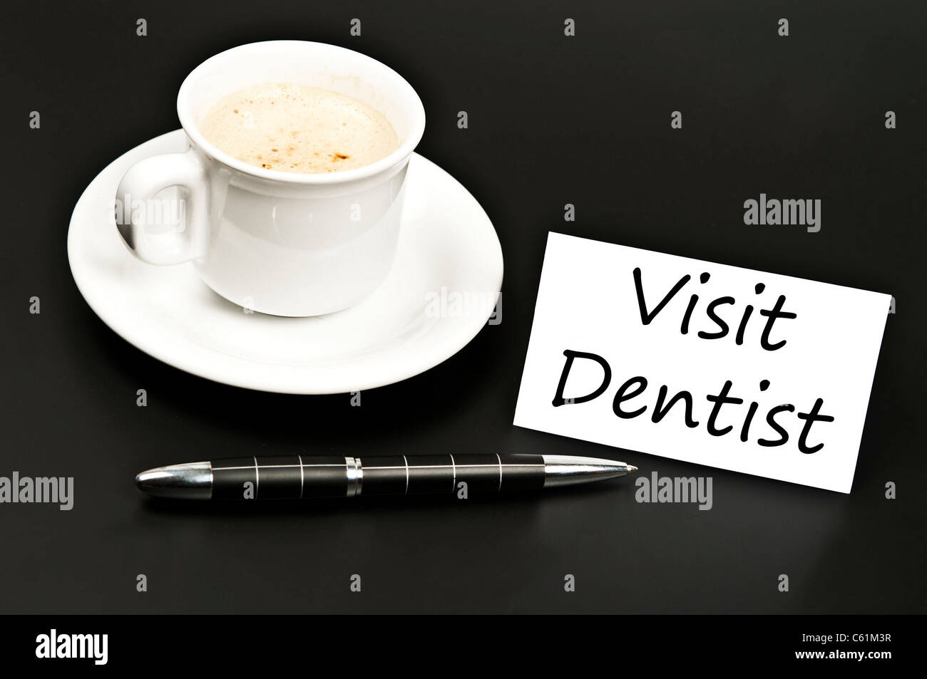 Visitare il dentista messaggio sulla scrivania con il caffè Foto Stock