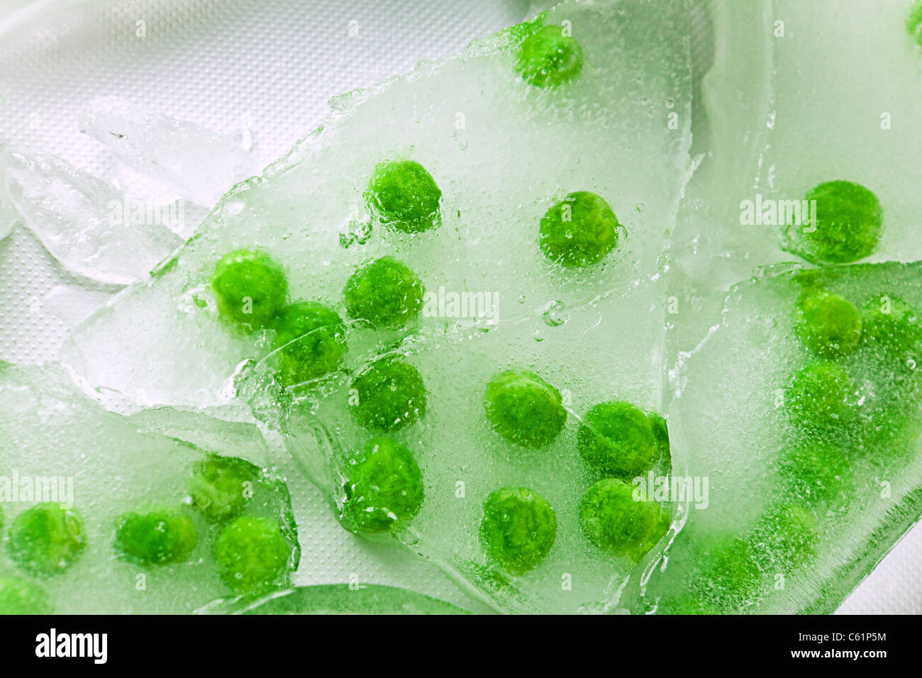 I piselli congelati in spessore di ghiaccio rotto Foto Stock