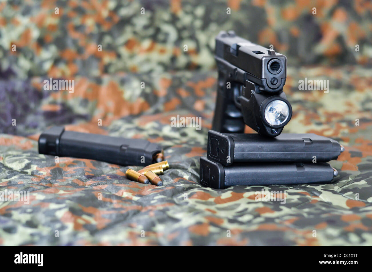 9mm Sidearm orrendo militare con una tattica di laser/luce-modulo sul mimetismo Foto Stock