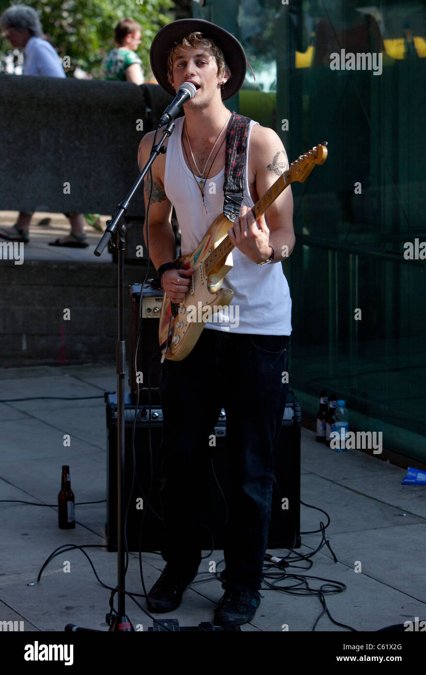 Ritratto a lunghezza intera di un busker maschile che suona una chitarra, Southbank, Londra, Inghilterra, Regno Unito. Foto Stock