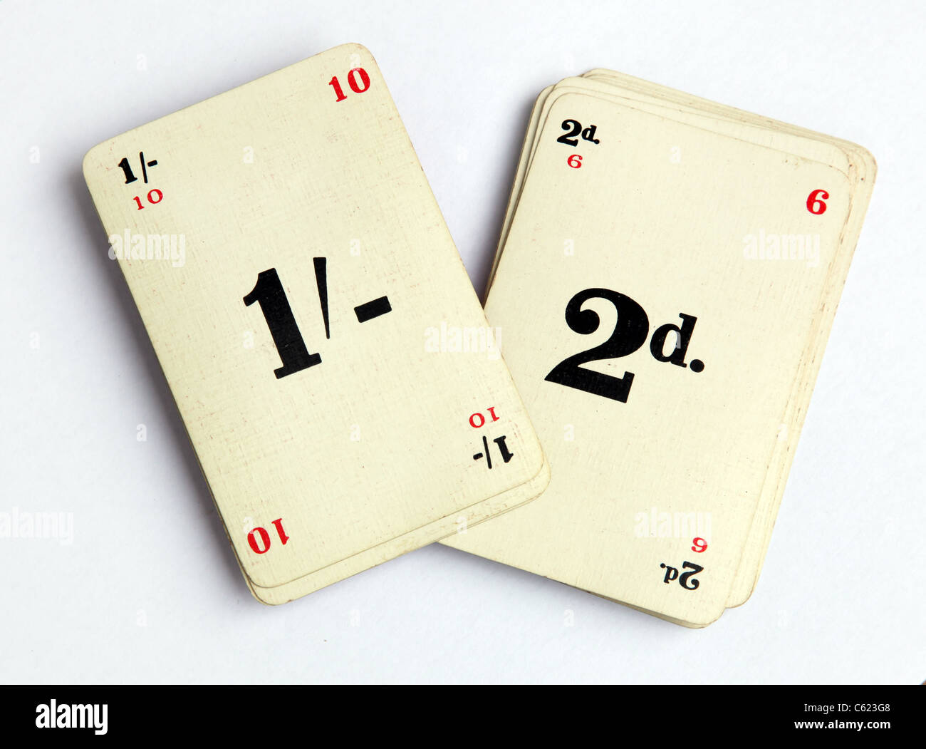 Somma-it giocando a carte gioco con uno scellino e 2 vecchi pence simboli. Foto Stock