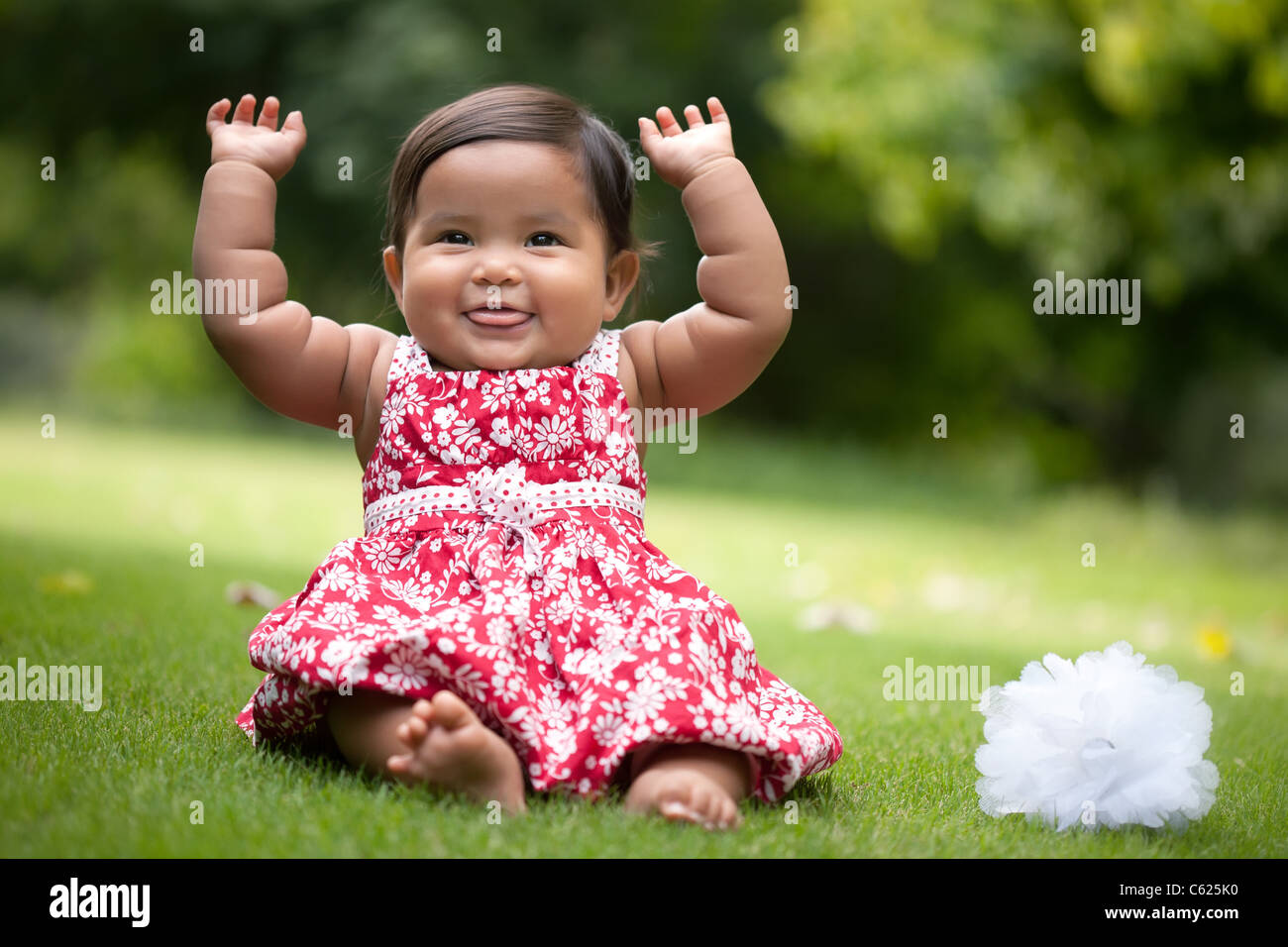 Carino Baby girl gesti con le braccia e soffiaggio di lamponi Foto Stock