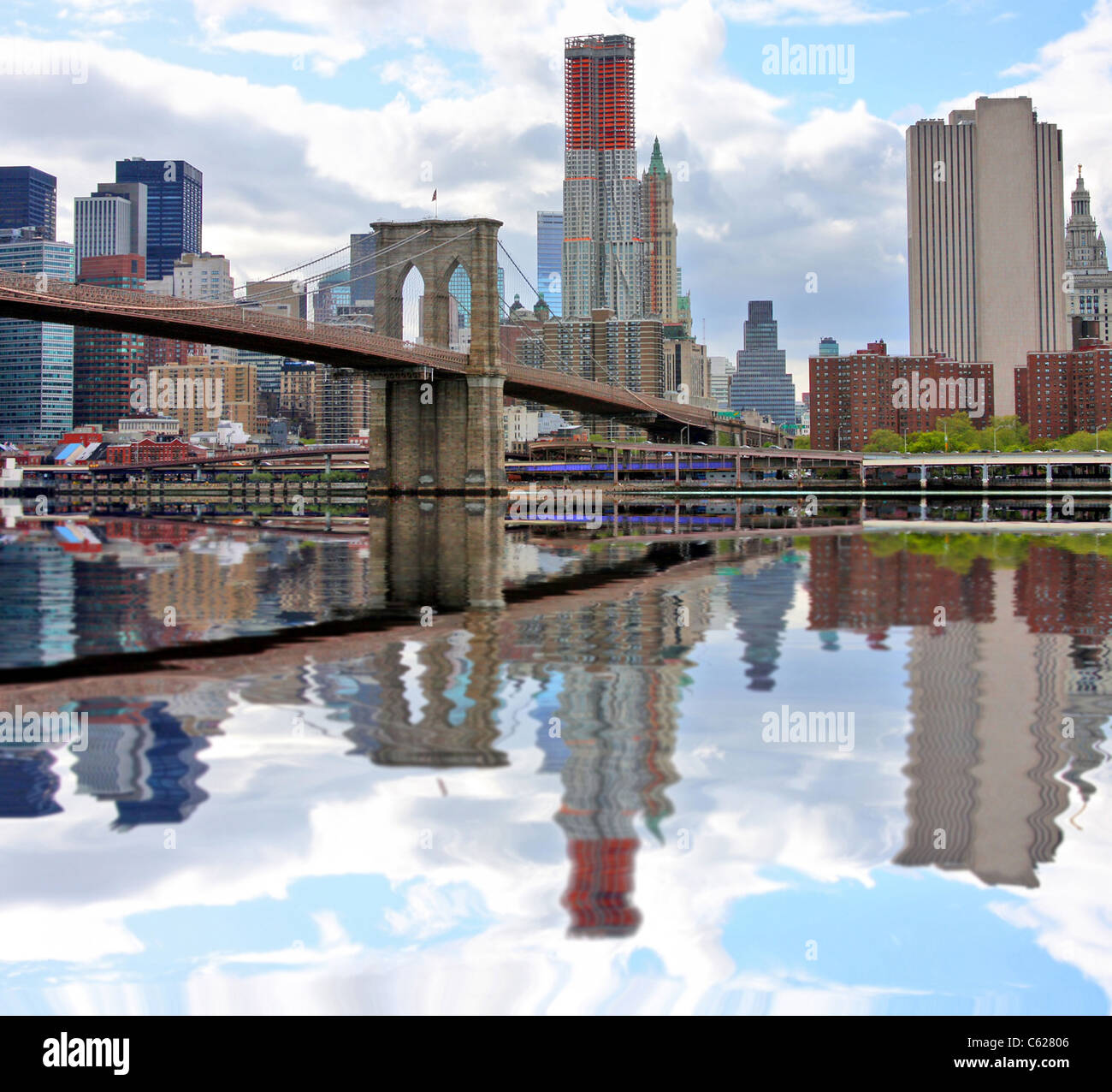 Il ponte di Brooklyn e la parte inferiore di Manhattan si riflette in East River Foto Stock