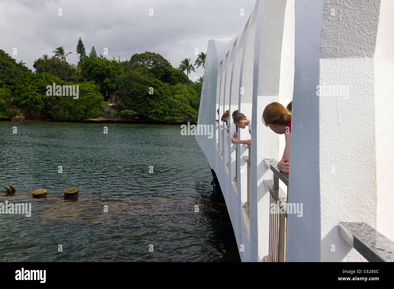 I visitatori di USS Arizona Memorial guardando in giù in acqua Foto Stock