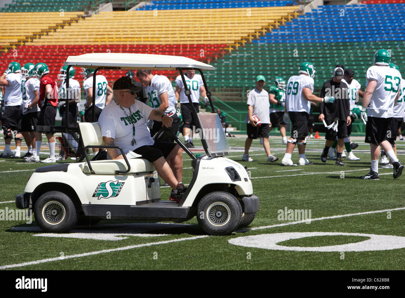 Il personale di coaching drive carrello da golf sul campo durante la saskatchewan roughriders allenamento pre stagione mosaic stadium campo di Taylor Foto Stock