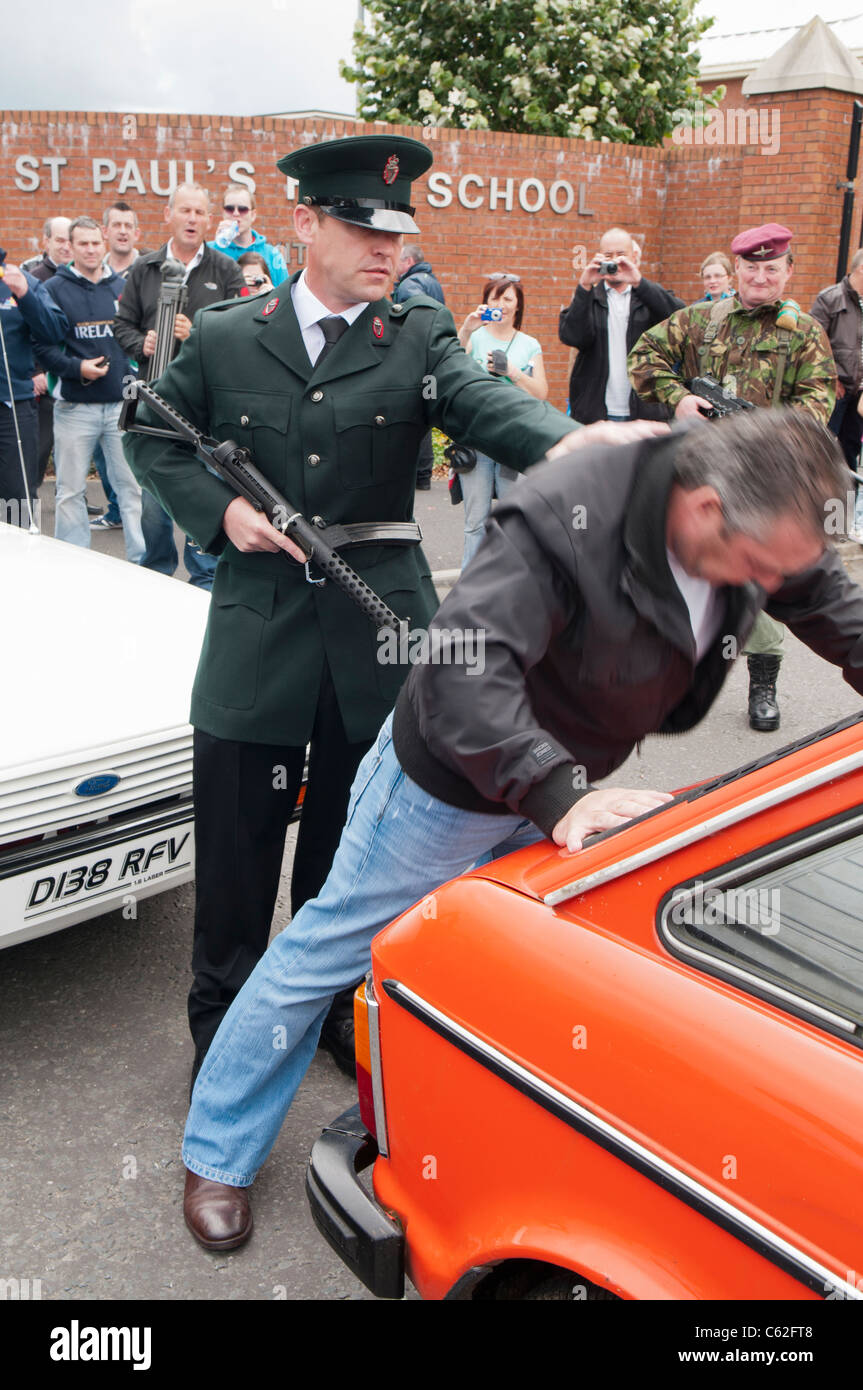 Uomini vestiti in RUC ed esercito uniformi reinterpreta un arresto e ricerca in Irlanda del Nord negli anni ottanta Foto Stock