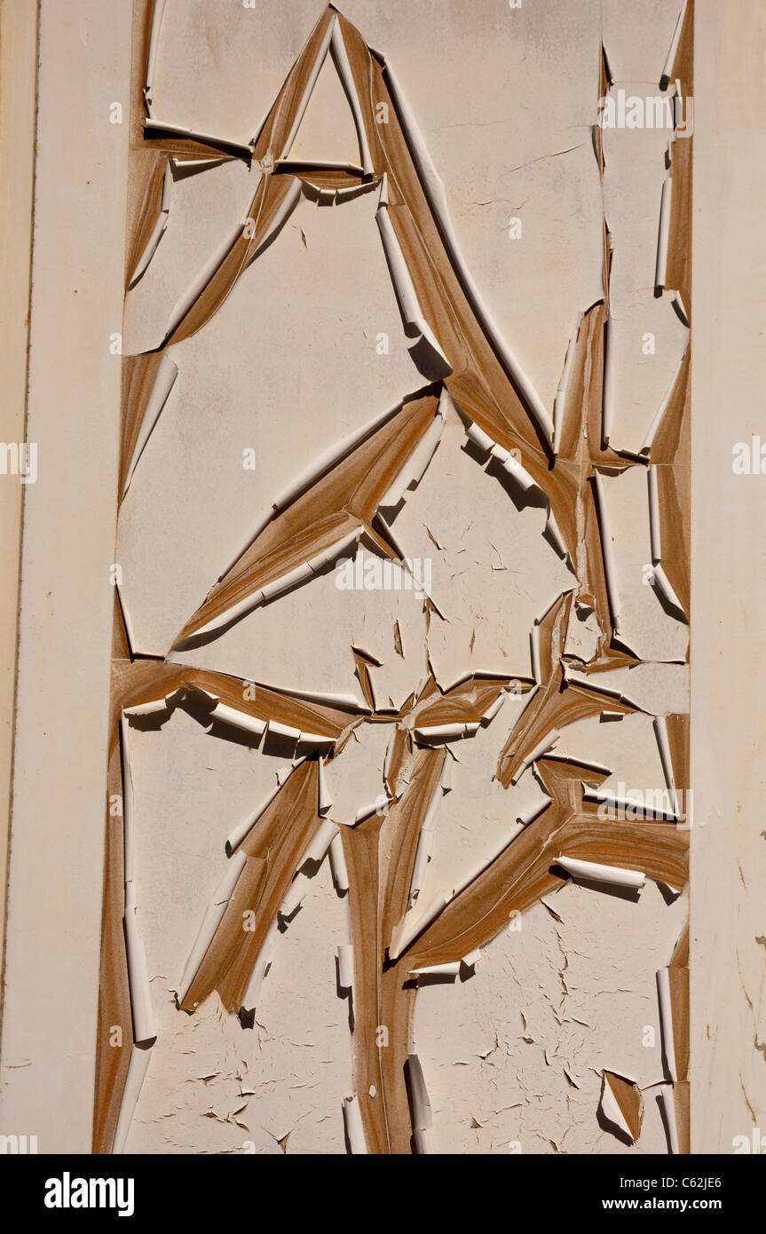 Un modello di sole vernice incrinato su una porta Foto Stock