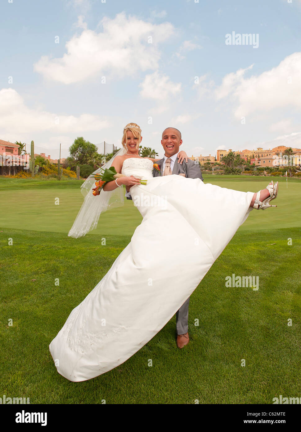 Sposa e lo Sposo godendo un momento sotto il sole presso la reception con un campo da golf Foto Stock