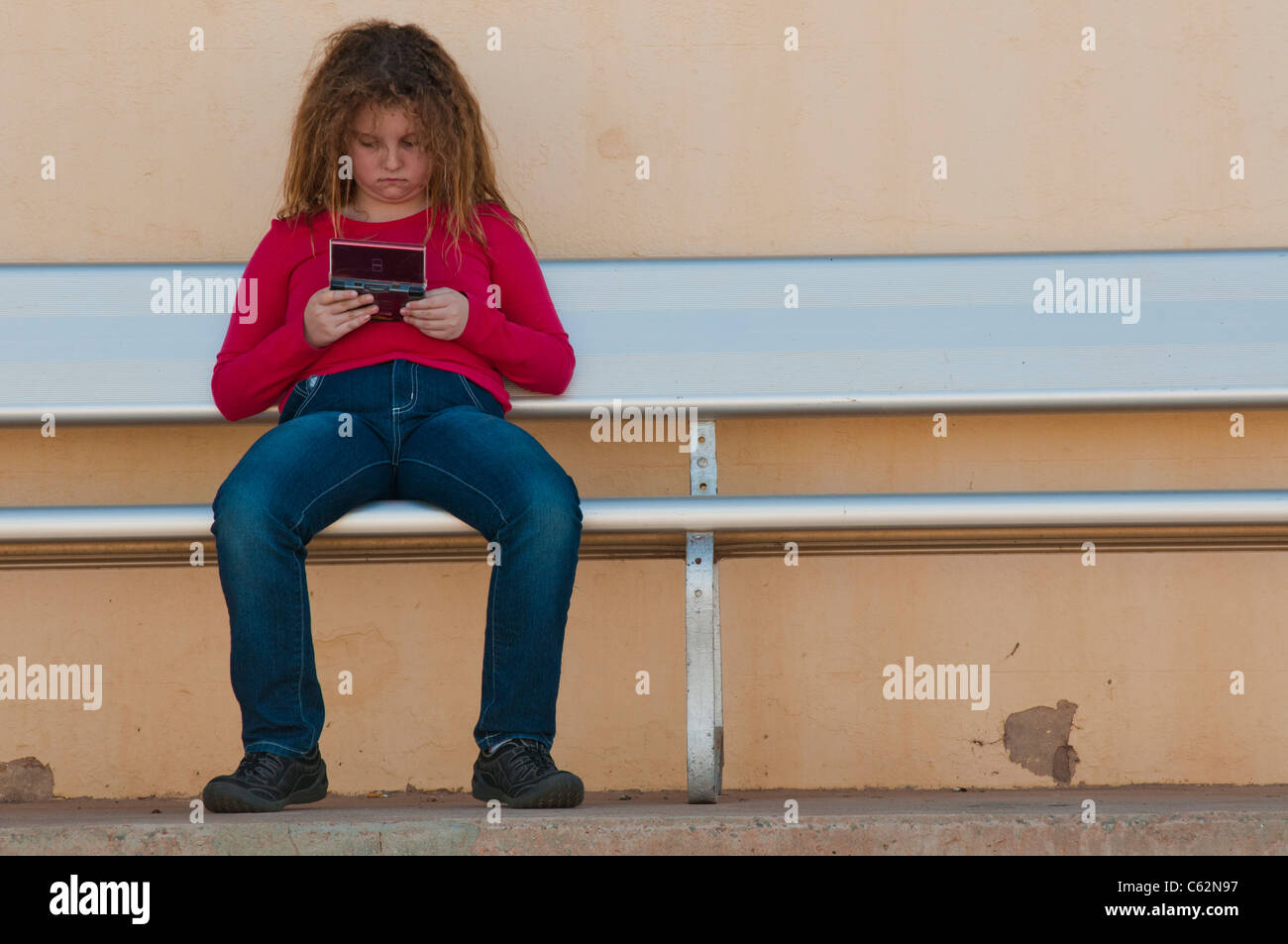 Ragazza adolescente giocando il gioco digitale sul banco di lavoro Foto Stock