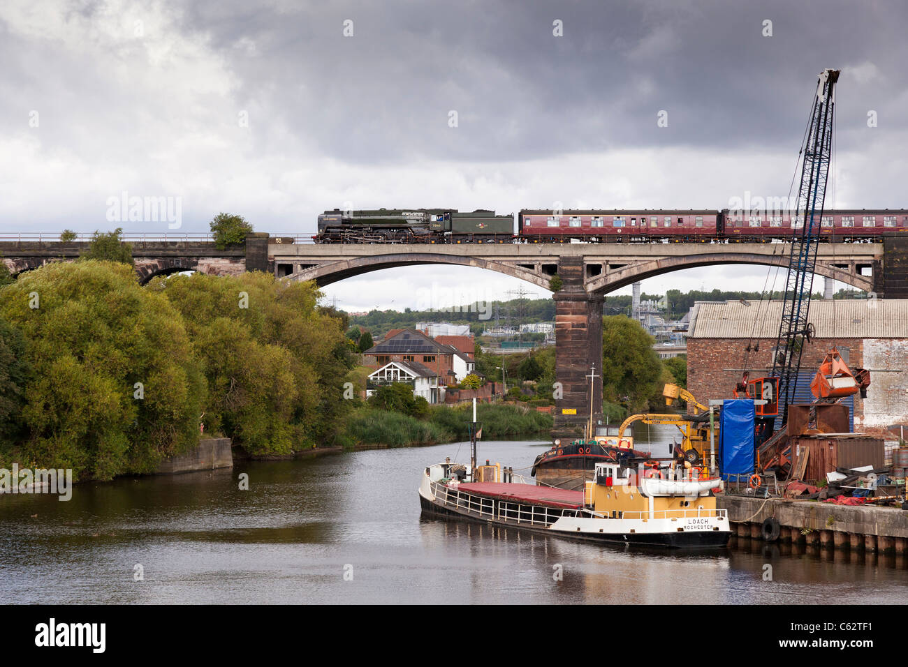 Il North Wales coast Express con BR vintage 4-6-0 n. 70013 Oliver Cromwell attraversa il fiume Weaver a Frodsham. Foto Stock
