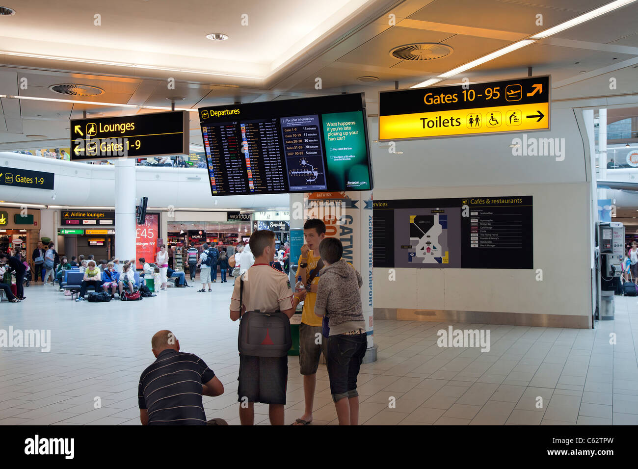 Volo Scheda Partenze aeroporto di Gatwick South Terminal UK elettronico destinazioni di vacanza vacanzieri segni di attesa wc Foto Stock