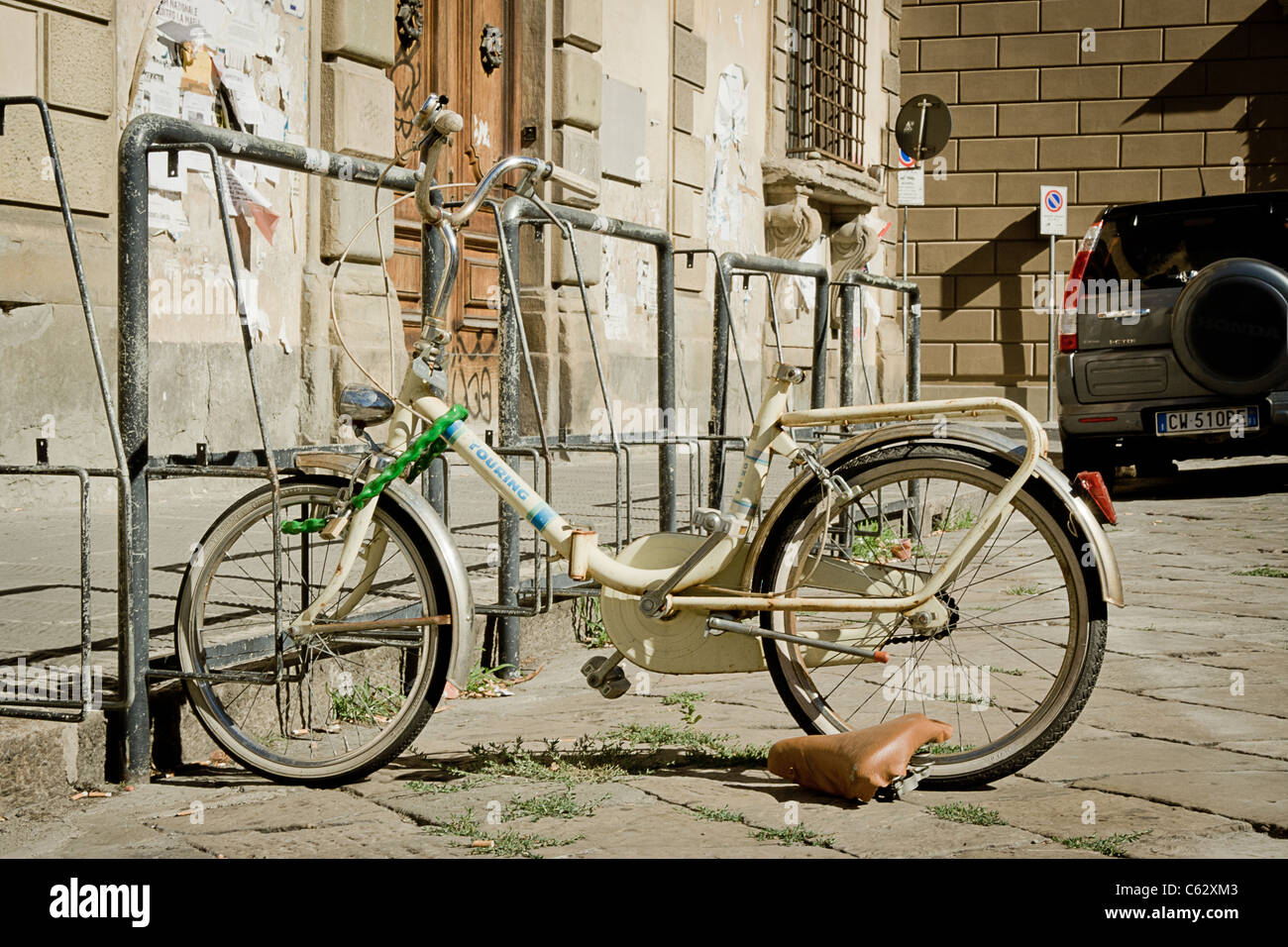 Un rotto e abbandonato bicicletta su una strada urbana Foto Stock