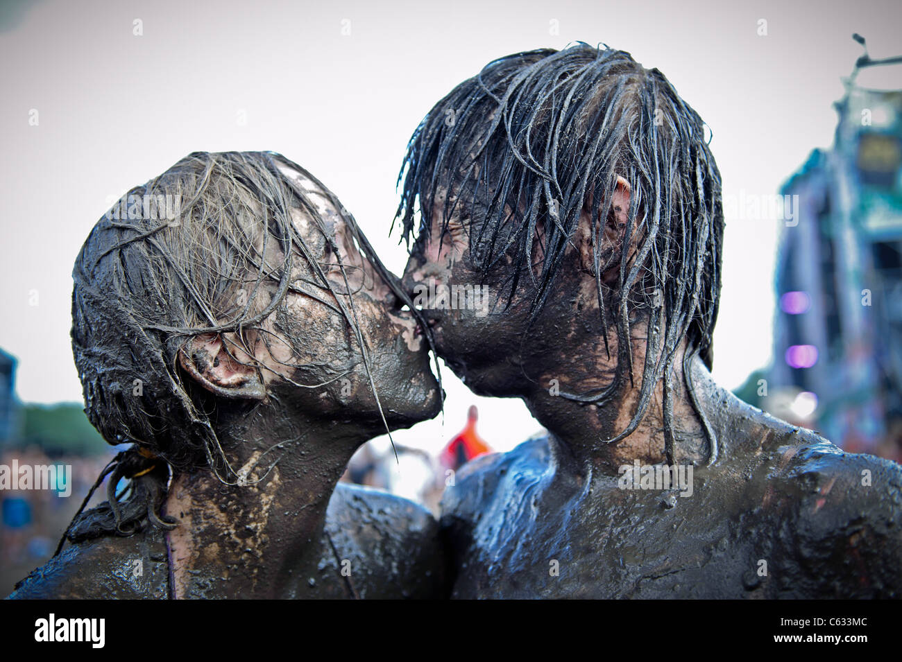 Coppia giovane kissing coperto di fango al Przystanek Woodstock - più grande d'Europa open air festival di Kostrzyn, Polonia Foto Stock