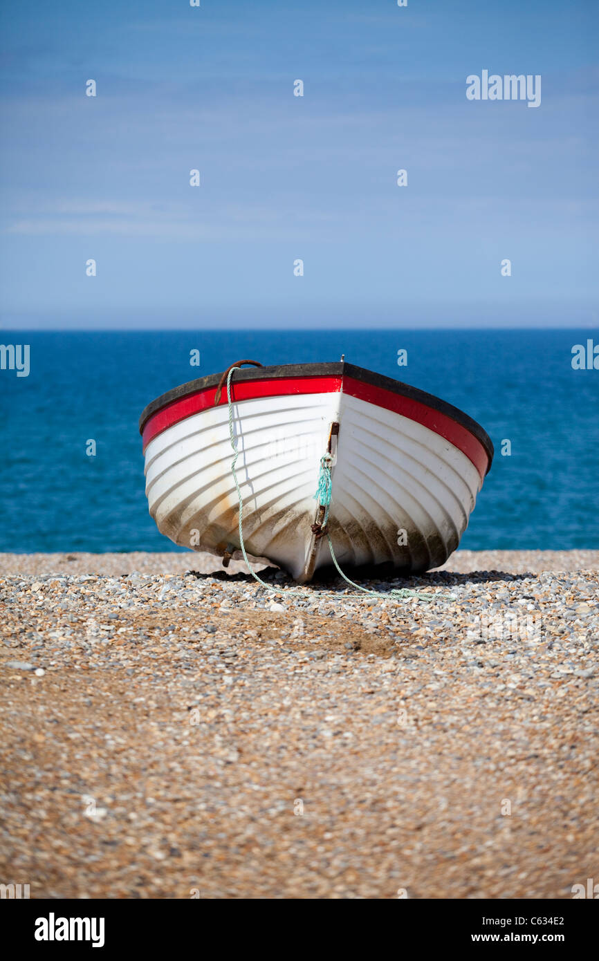 Una barca a remi sulla spiaggia a Cley-next-il-mare in North Norfolk, Regno Unito Foto Stock