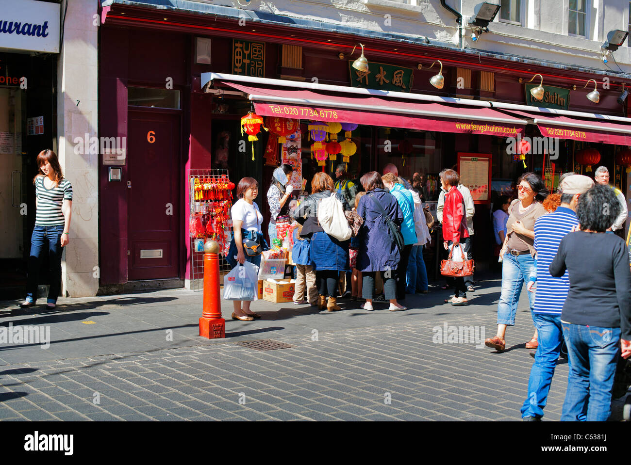 Scena di strada, i cacciatori di offerte folla in stallo al di fuori del negozio, China Town, Londra, Regno Unito, Europa Foto Stock