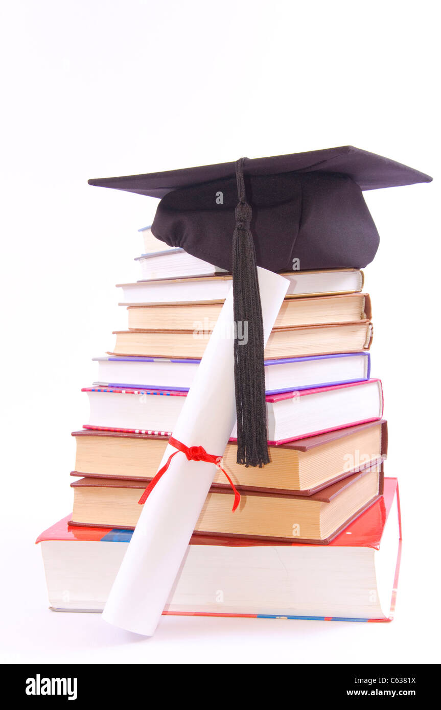 Student hat su una torre fatta di libri, contro uno sfondo bianco - concetto di istruzione Foto Stock