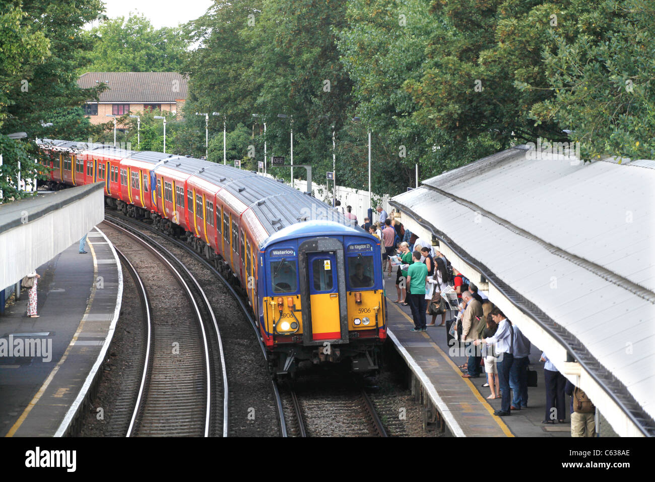 Pendolari di salire a bordo del treno di mattina a Mortlake, Londra Foto Stock