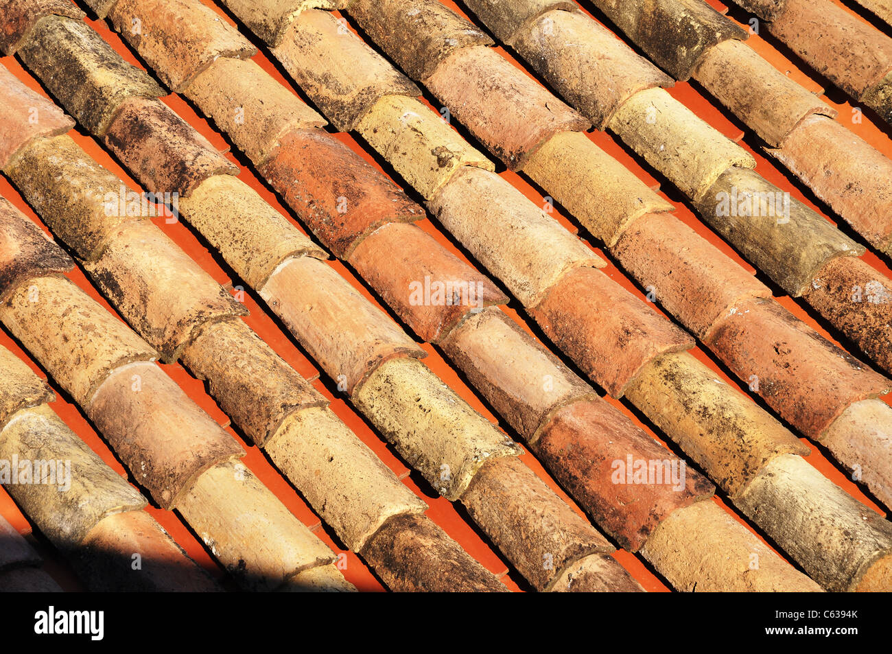 Antiche tegole del tetto in diversi colori di rosso Foto Stock